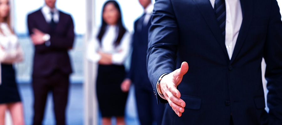 Young business man standing in front of his co-workers  talking